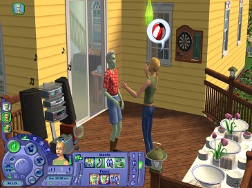 Two animated characters from The Sims 2 are standing and chatting inside a cozy, yellow house with a patterned wooden floor, while a computer and stereo are visible nearby, and a table with a floral tablecloth is set with dishes.